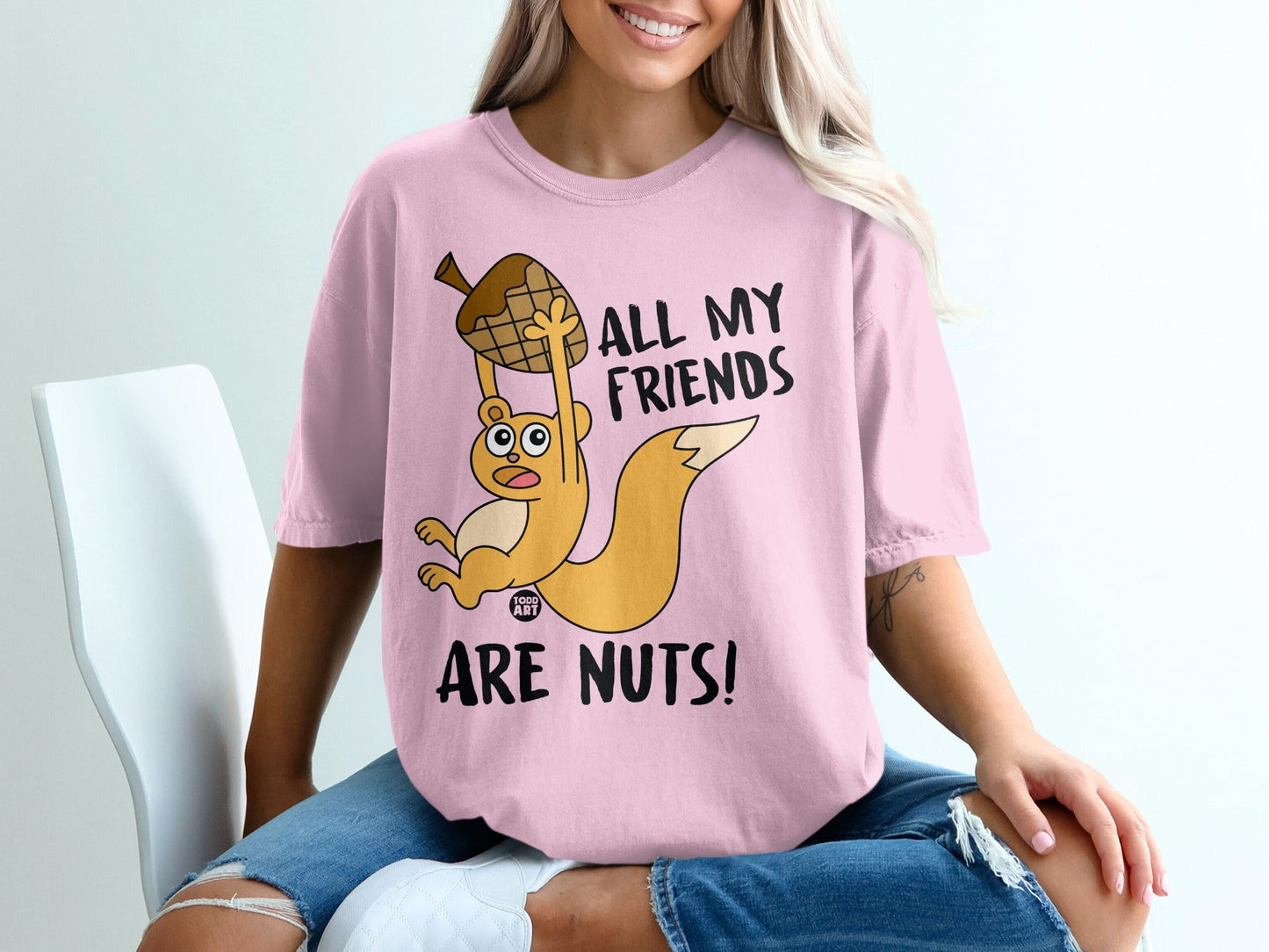 Pink t-shirt with cartoon squirrel holding acorn, text reads "All My Friends Are Nuts!".