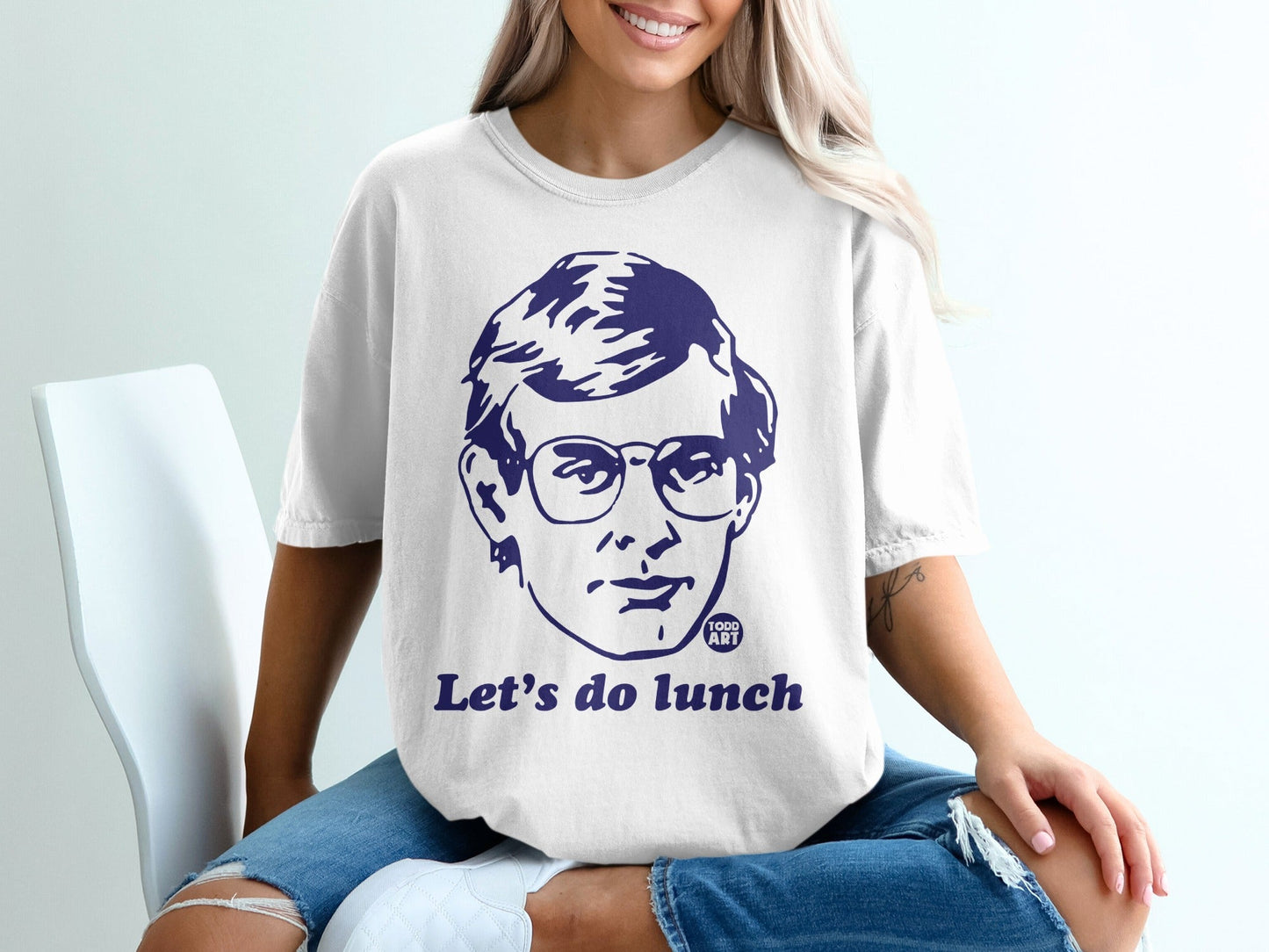 White t-shirt with dark blue graphic of a man's face and "Let's do lunch."