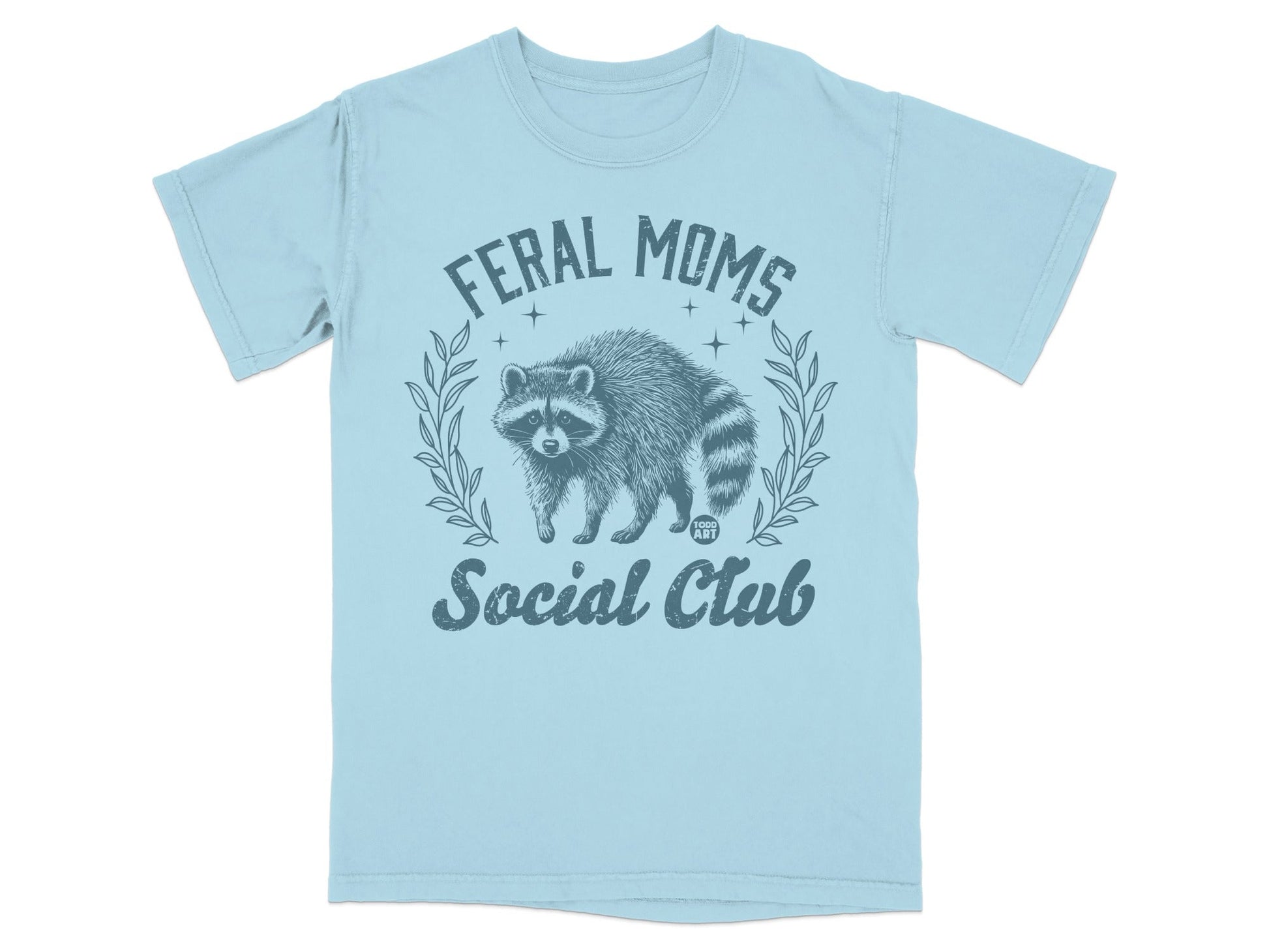 Light blue t-shirt with distressed raccoon graphic and text "Feral Moms Social Club".