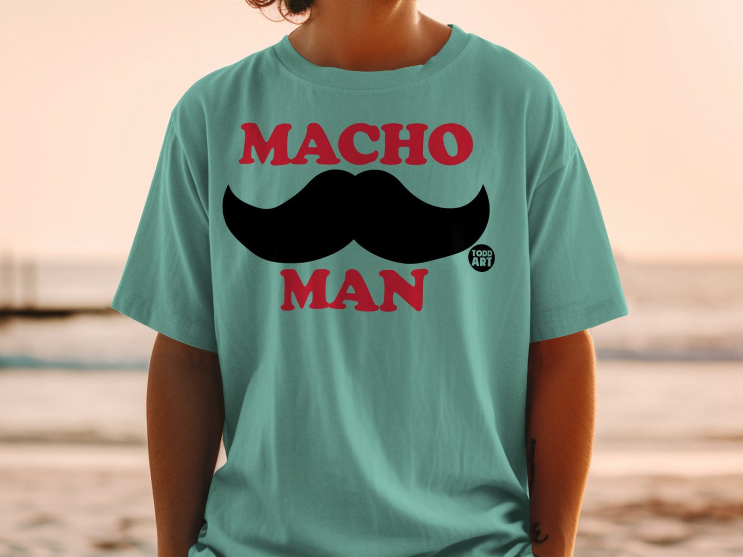 Teal t-shirt with black mustache and "MACHO MAN" text.