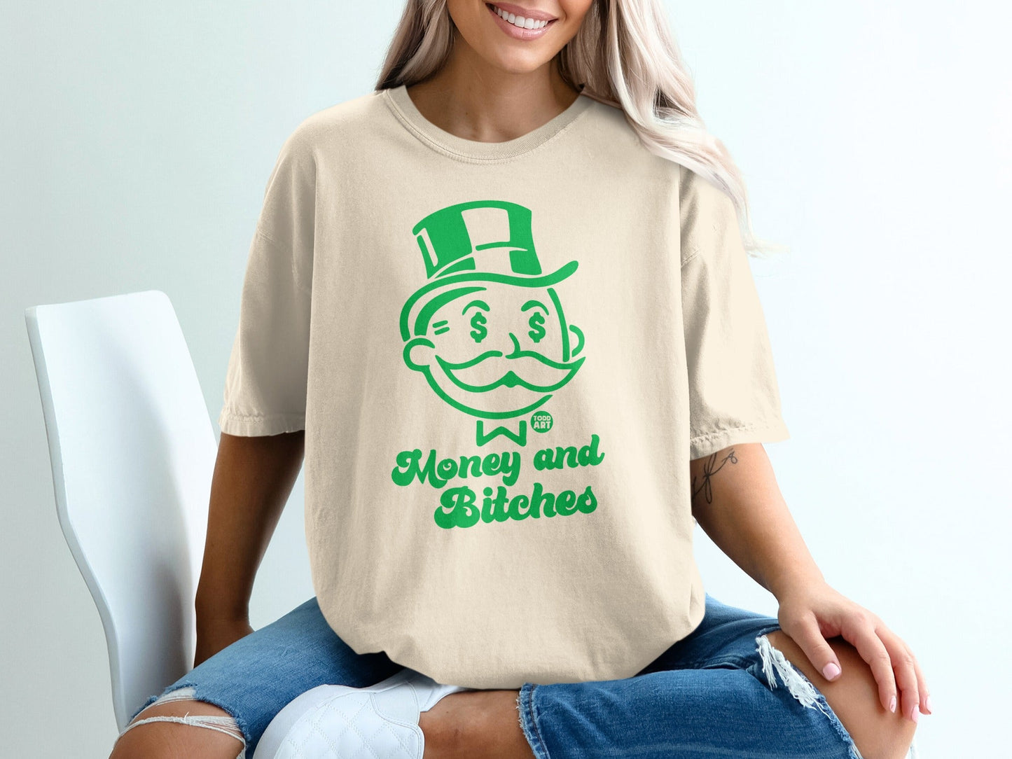 Cream t-shirt with green Monopoly man graphic and "Money and Bitches" text.