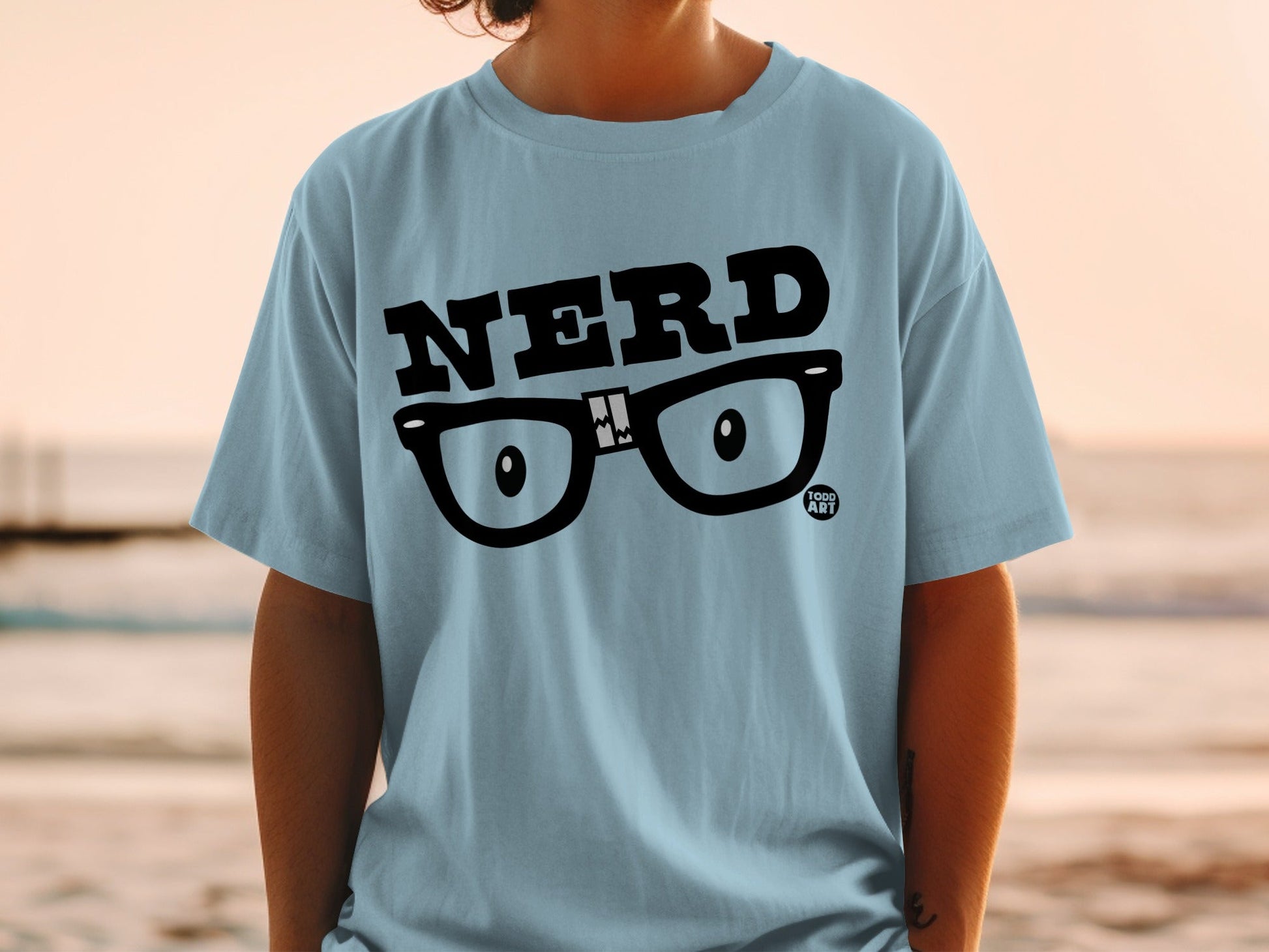 Light blue t-shirt with "NERD" text and cartoon glasses graphic.