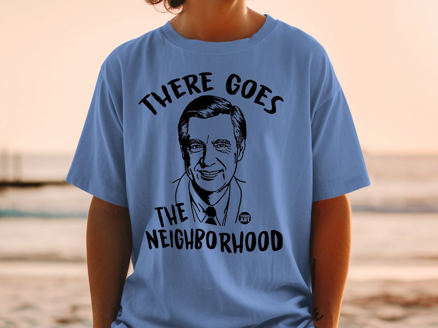 T-shirt with Fred Rogers illustration and "There Goes The Neighborhood" text.