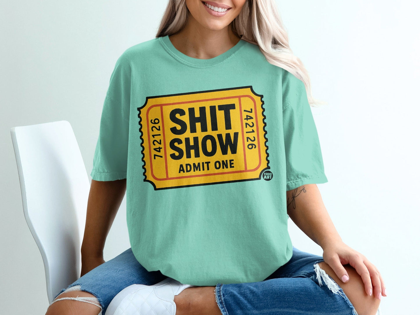 Teal t-shirt with "Shit Show Admit One" ticket design.