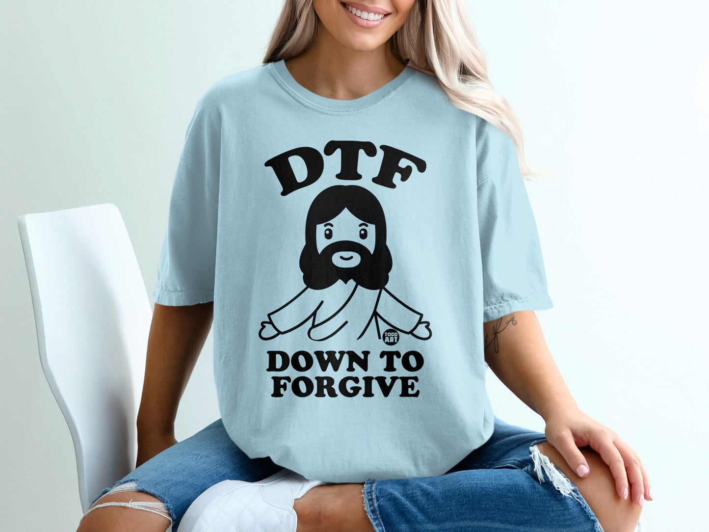 Light blue t-shirt with "DTF DOWN TO FORGIVE" text and cartoon Jesus graphic.