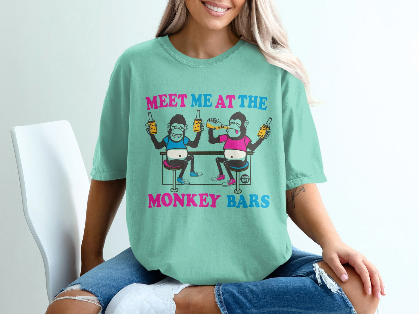 T-shirt with cartoon monkeys holding beers at a bar.