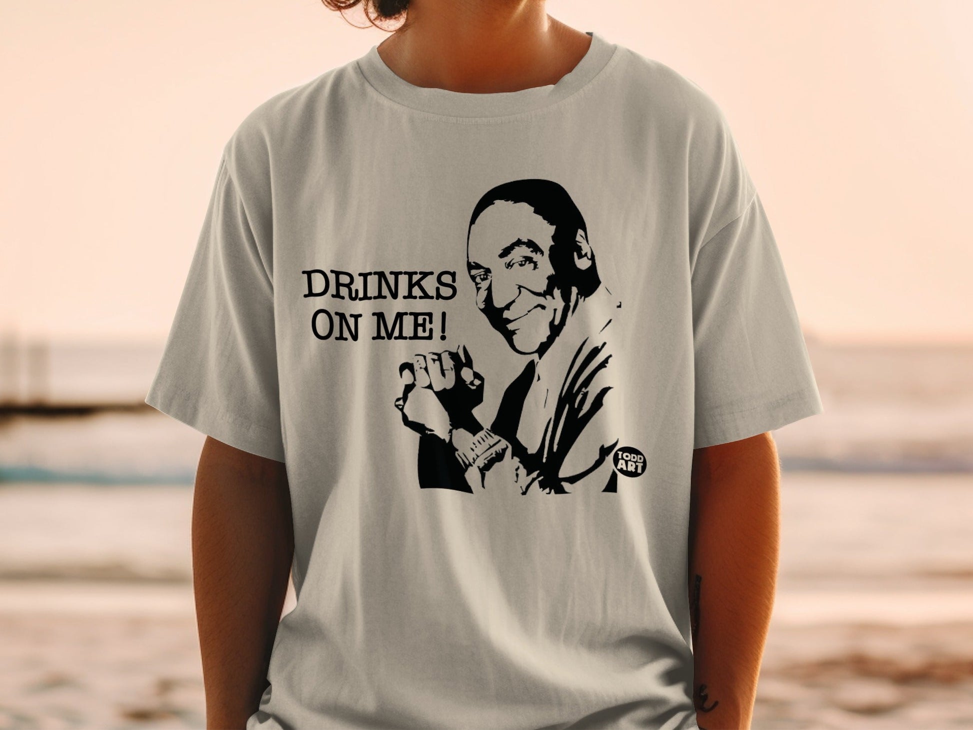 T-shirt with a black and white graphic of a man saying "DRINKS ON ME!".
