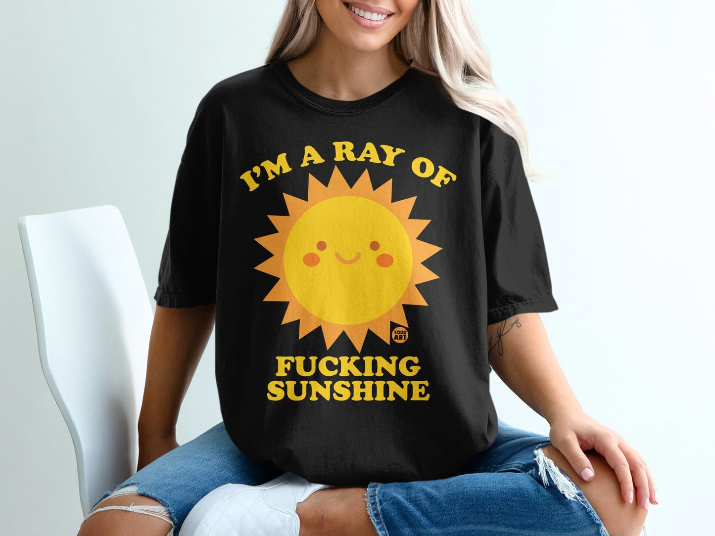 Black t-shirt with yellow sun graphic and "I'M A RAY OF FUCKING SUNSHINE" text.