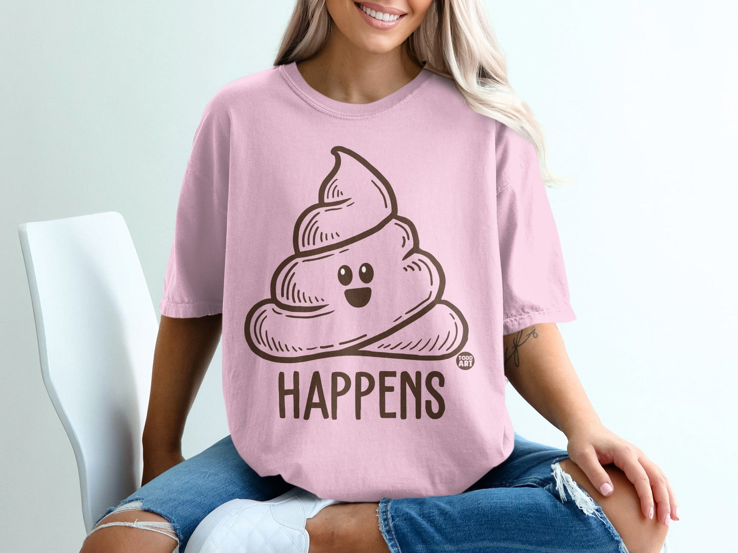 Pink t-shirt with cartoon smiling poop and text "SHIT HAPPENS".