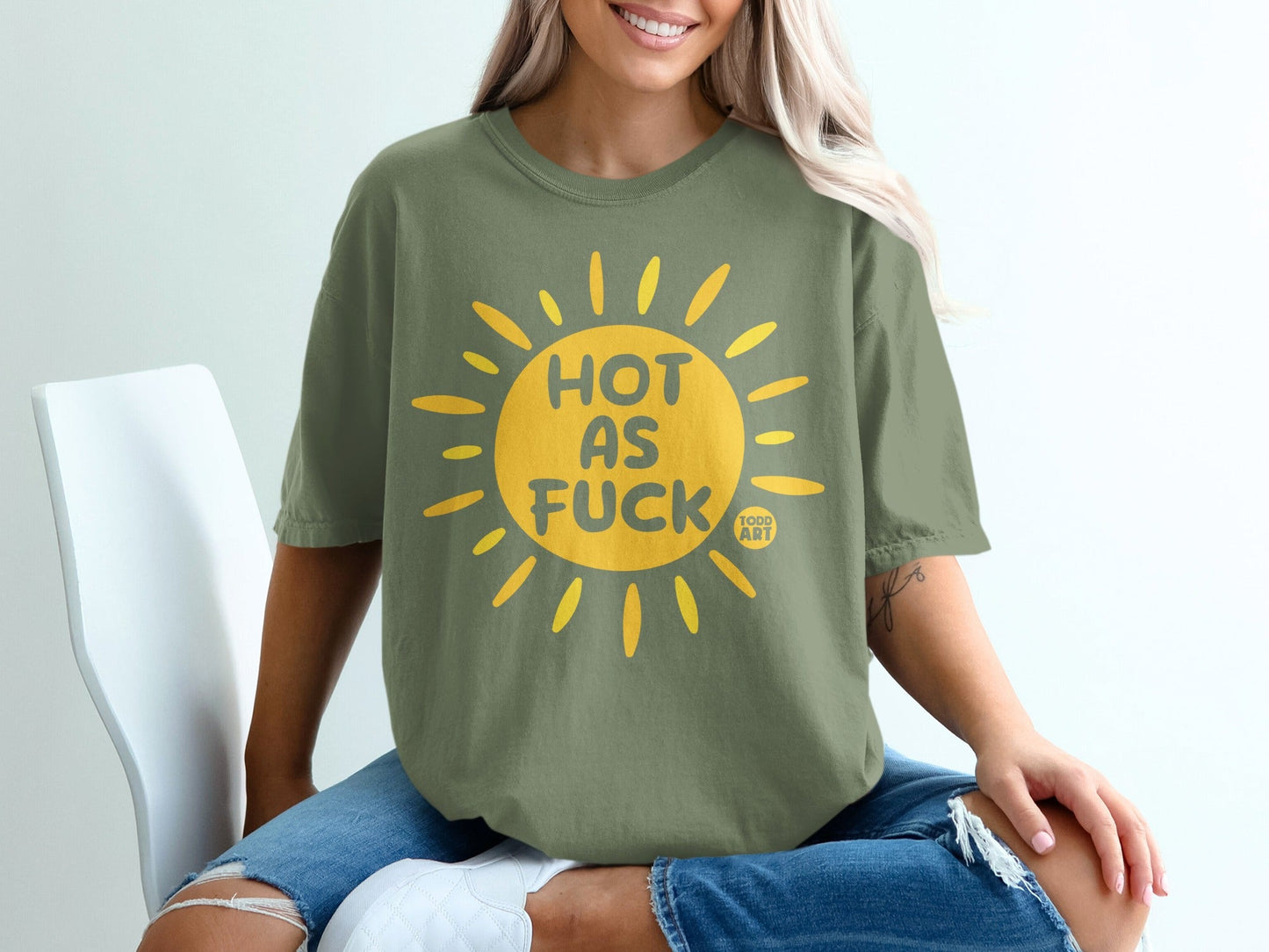 Olive green t-shirt with yellow sun graphic and text "HOT AS FUCK".