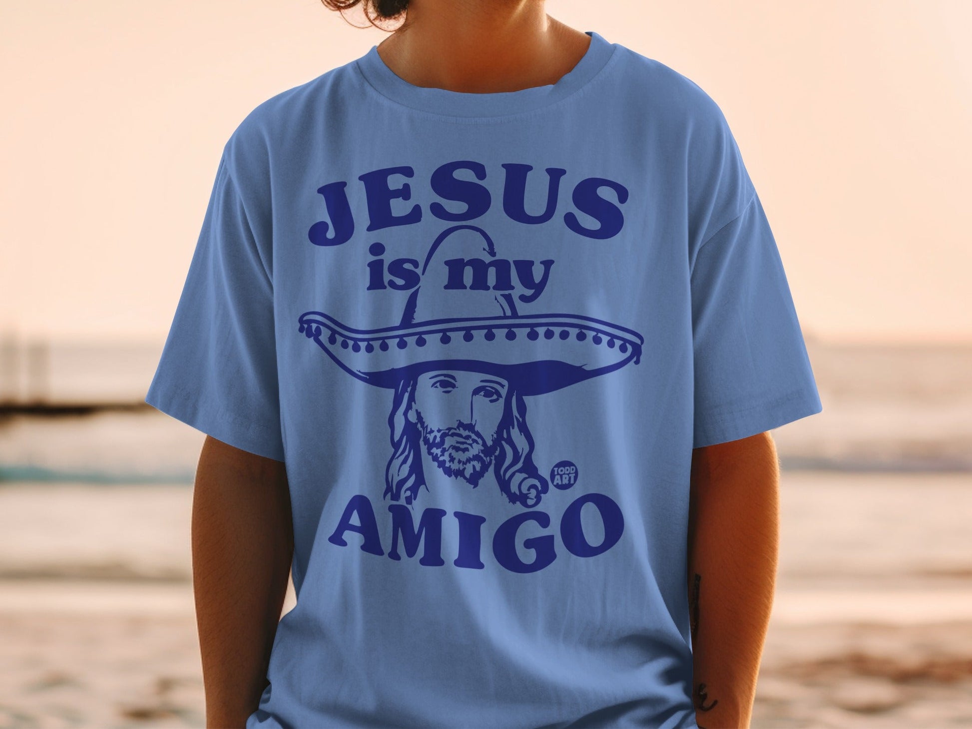 Blue t-shirt with "Jesus is my amigo" text and a sombrero-wearing Jesus graphic.