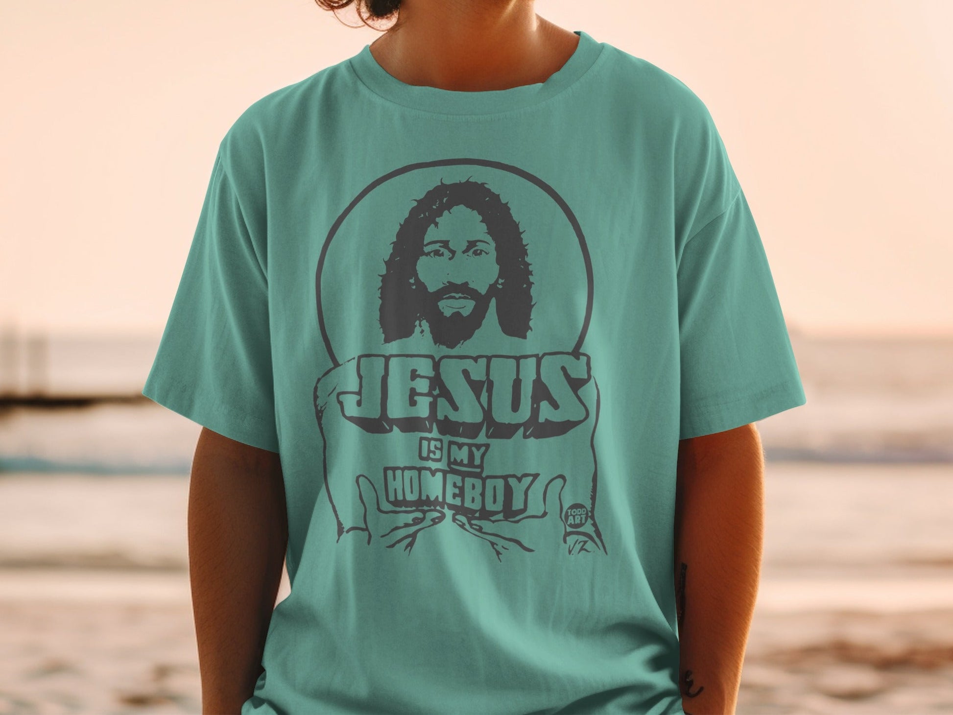 Teal t-shirt with graphic of Jesus and text "Jesus Is My Homeboy".