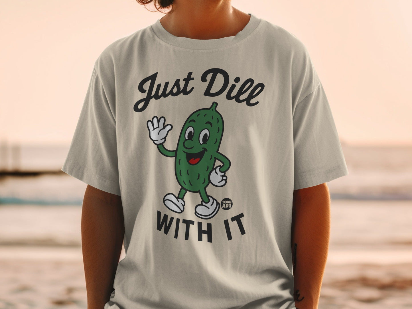 T-shirt with a cartoon pickle waving and the text "Just Dill With It."