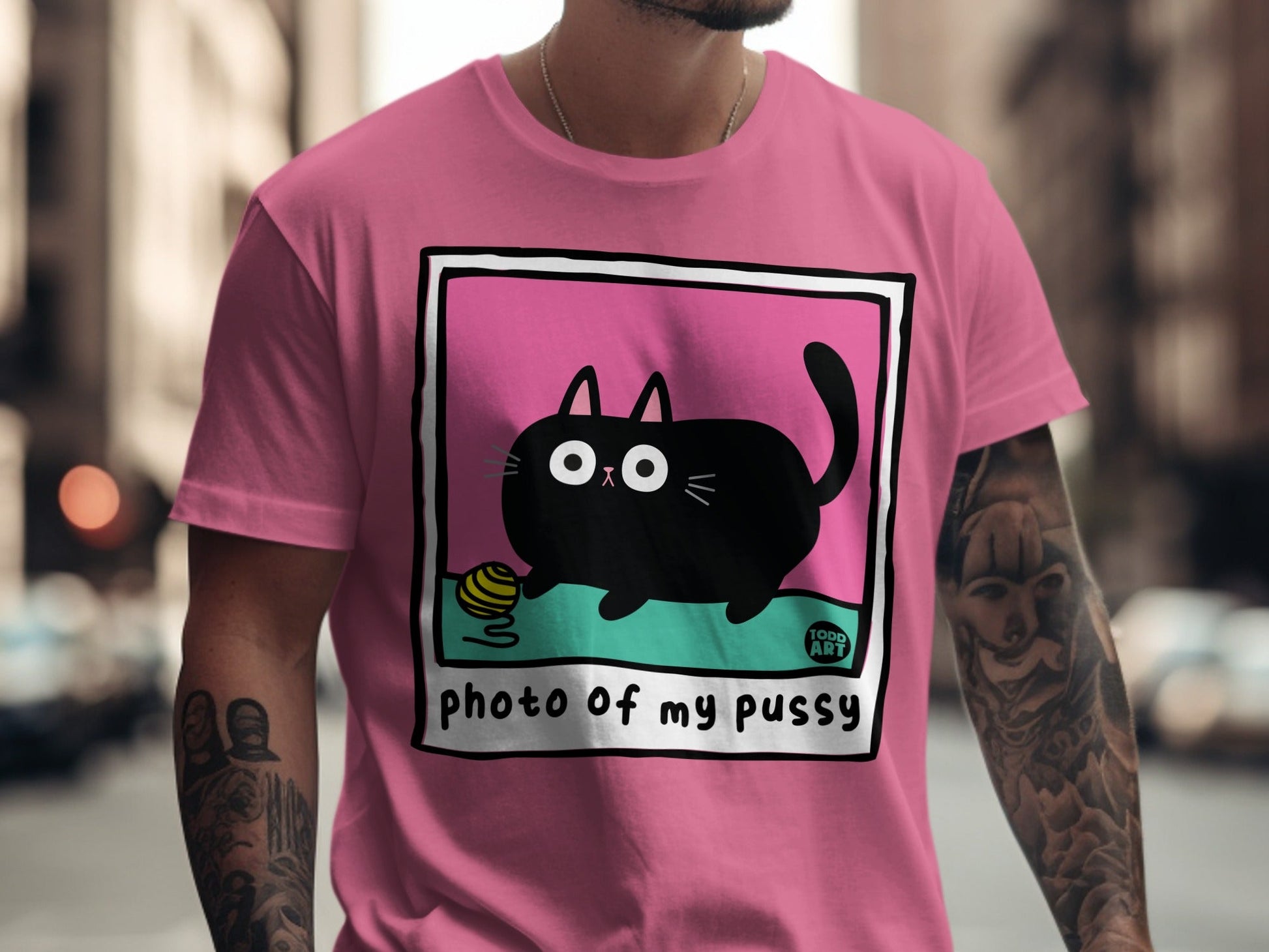 Black cat with yarn ball on pink shirt, "PHOTO of my pussy" text.