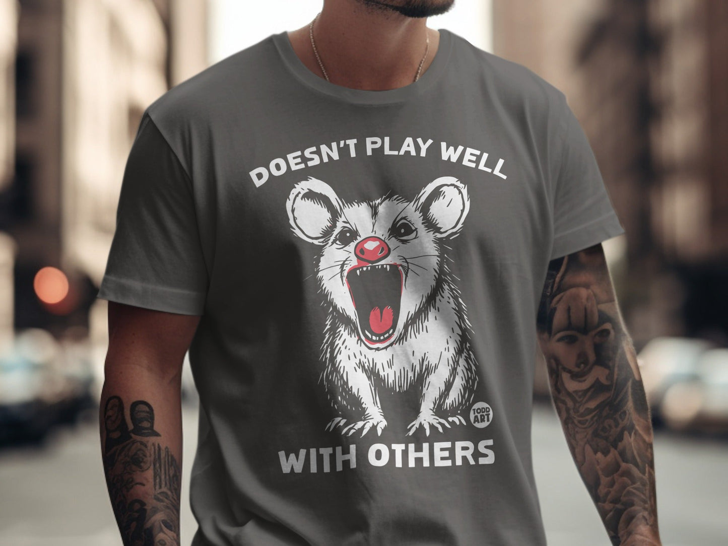 Dark grey t-shirt with a screaming possum and "DOESN'T PLAY WELL WITH OTHERS" text.