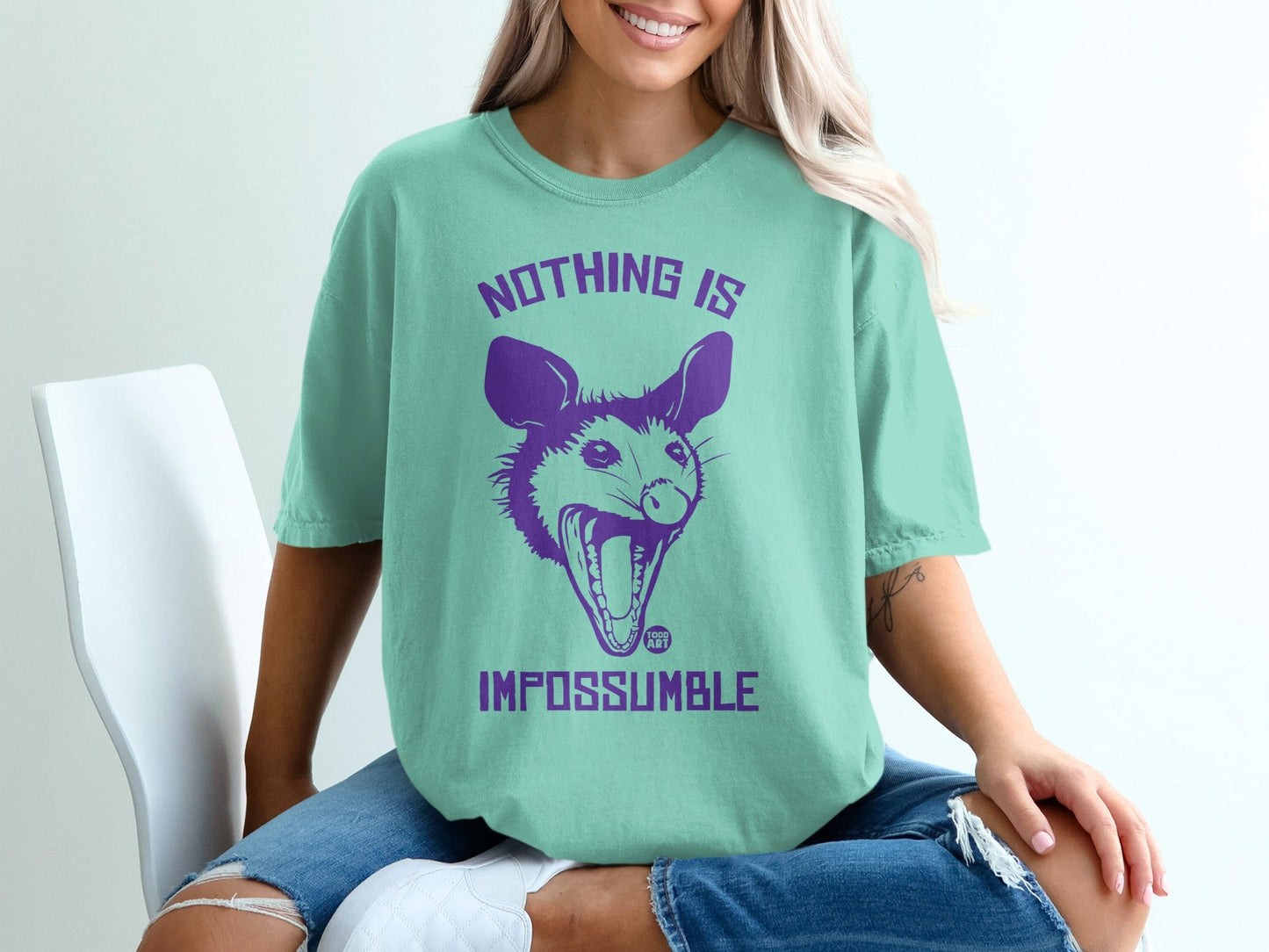 T-shirt with purple opossum and text "Nothing Is Imposs-um-ble".