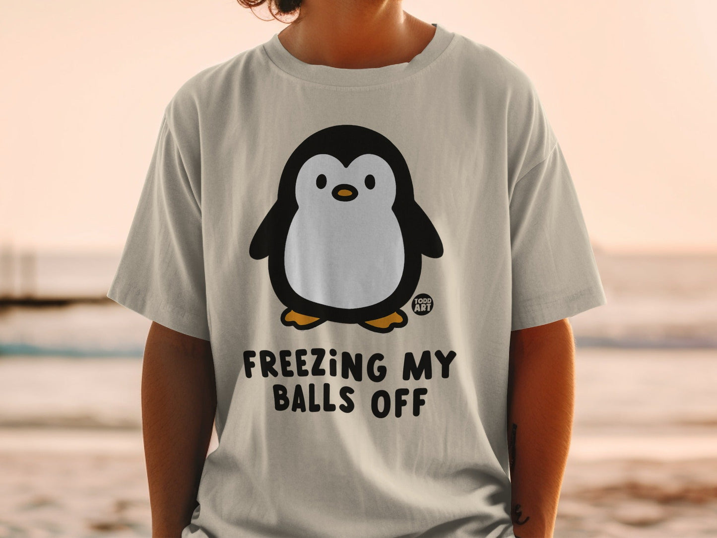 T-shirt with a cartoon penguin and text "FREEZING MY BALLS OFF".