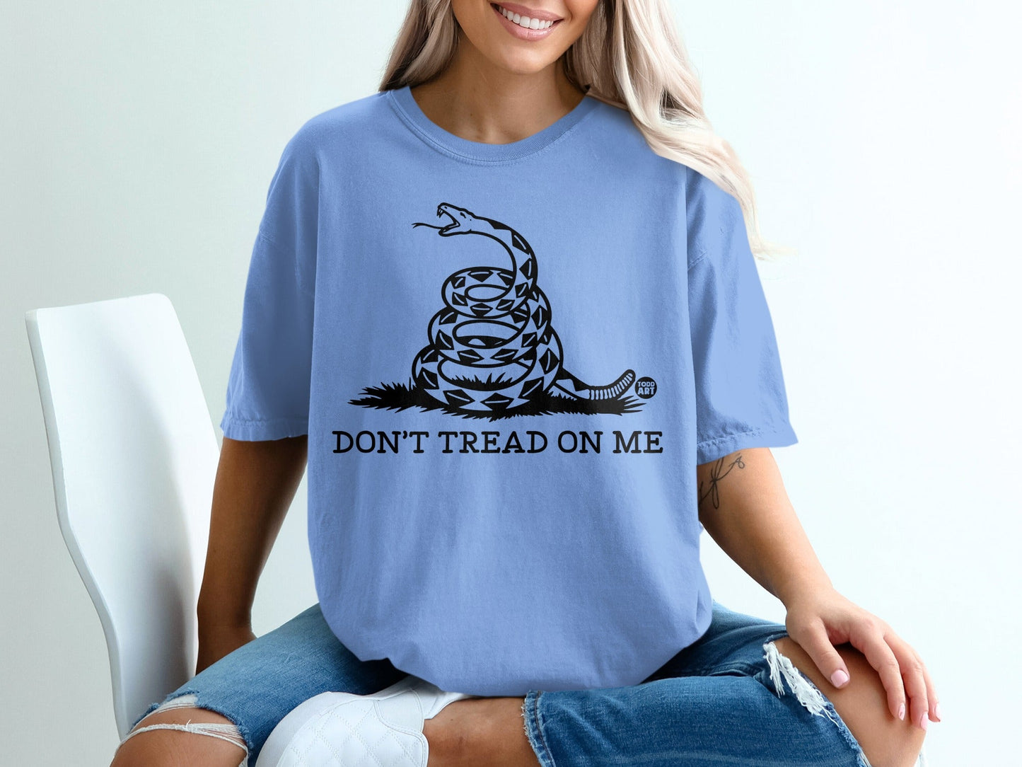 Light blue t-shirt with coiled snake and "DON'T TREAD ON ME" text.