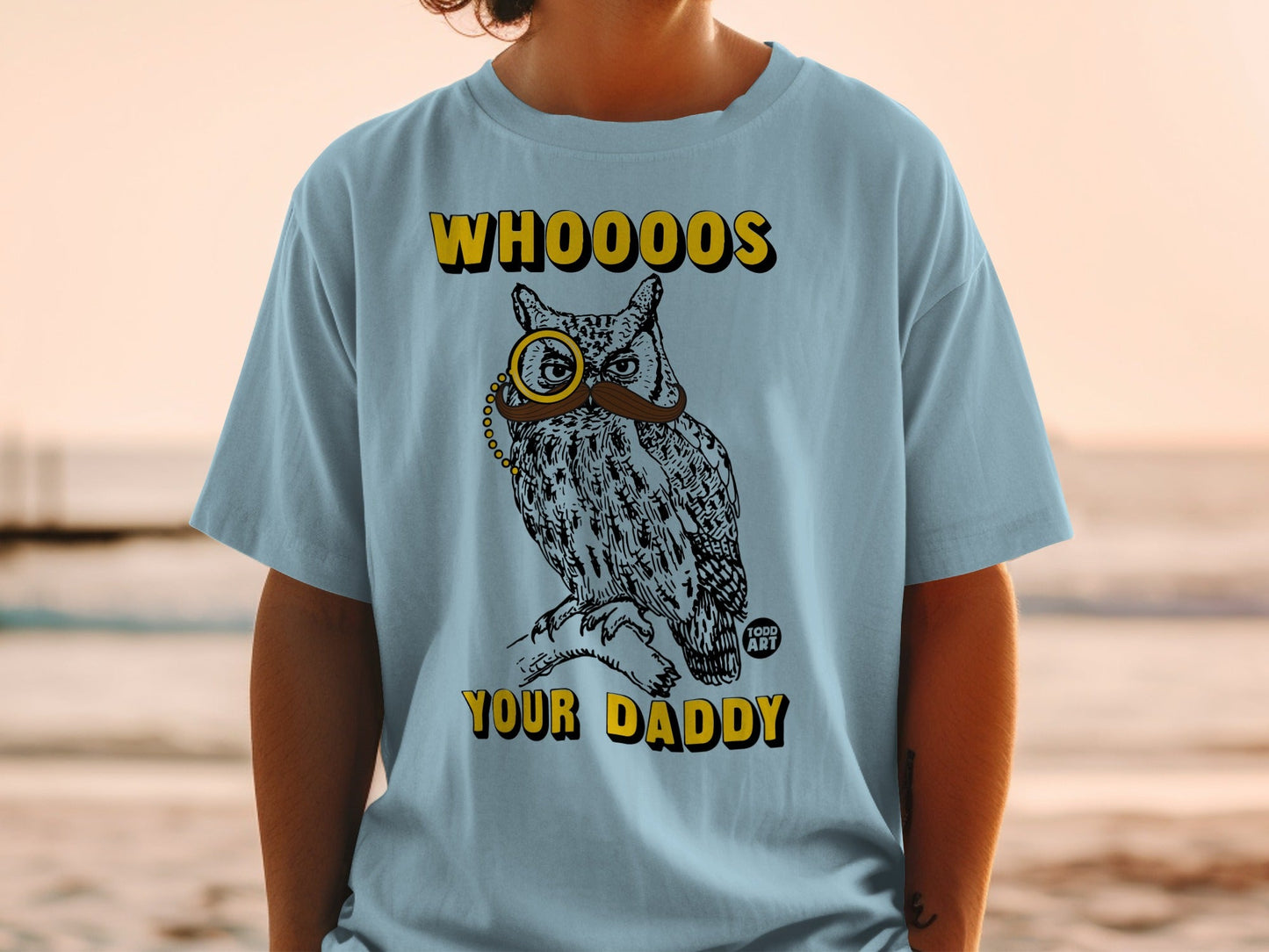 Owl wearing a monocle and mustache on a light blue t-shirt with text.