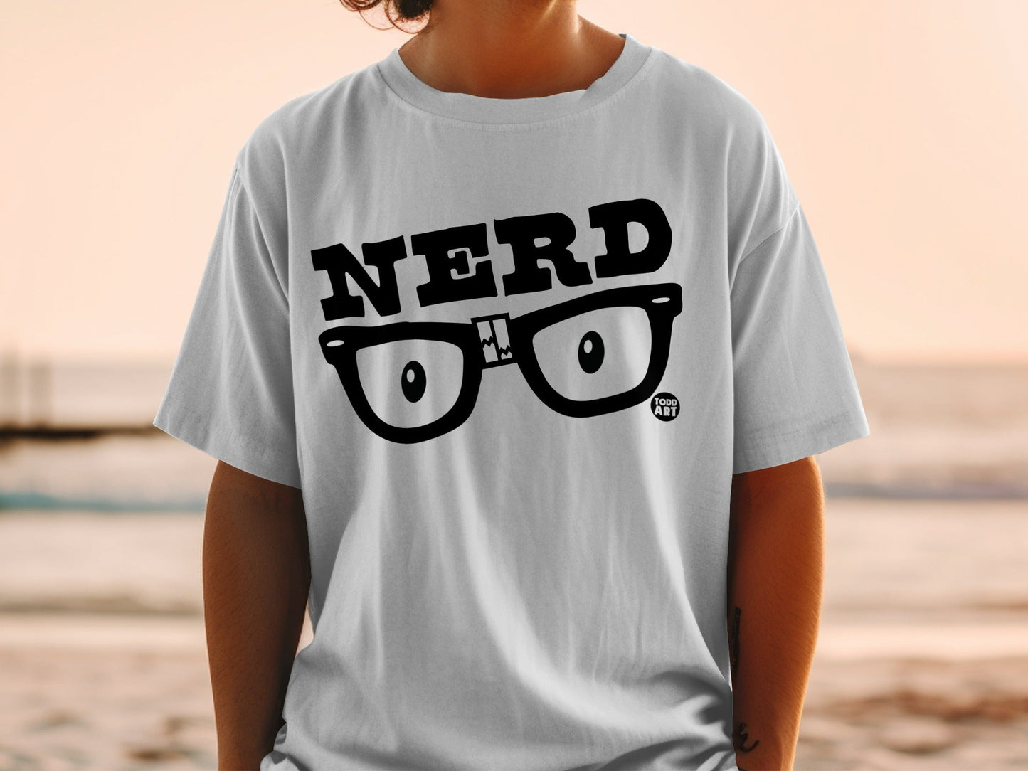 White t-shirt with black "NERD" text and cartoon glasses graphic.