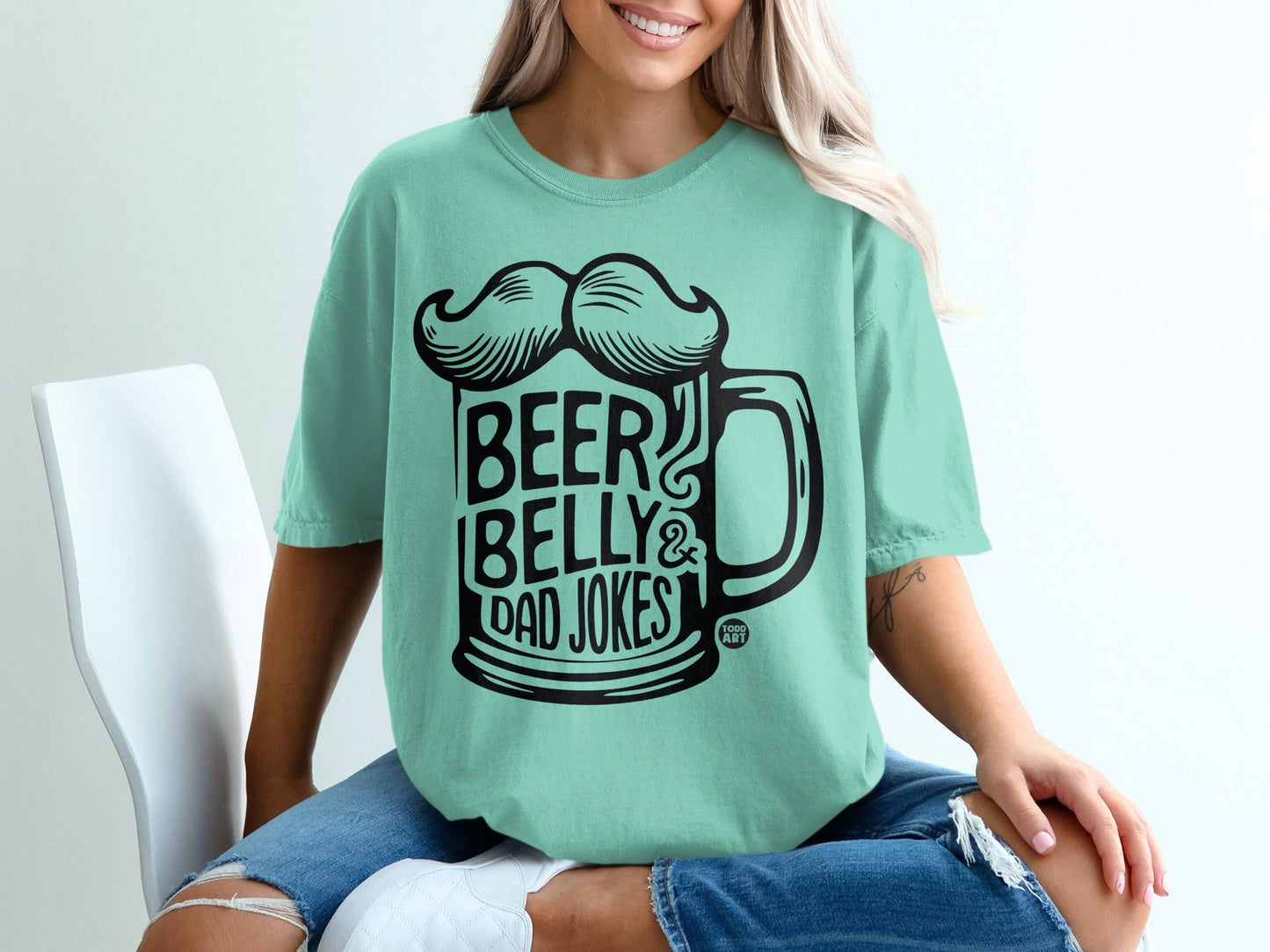 Teal t-shirt with black graphic of a beer mug and text "BEER BELLY & DAD JOKES".