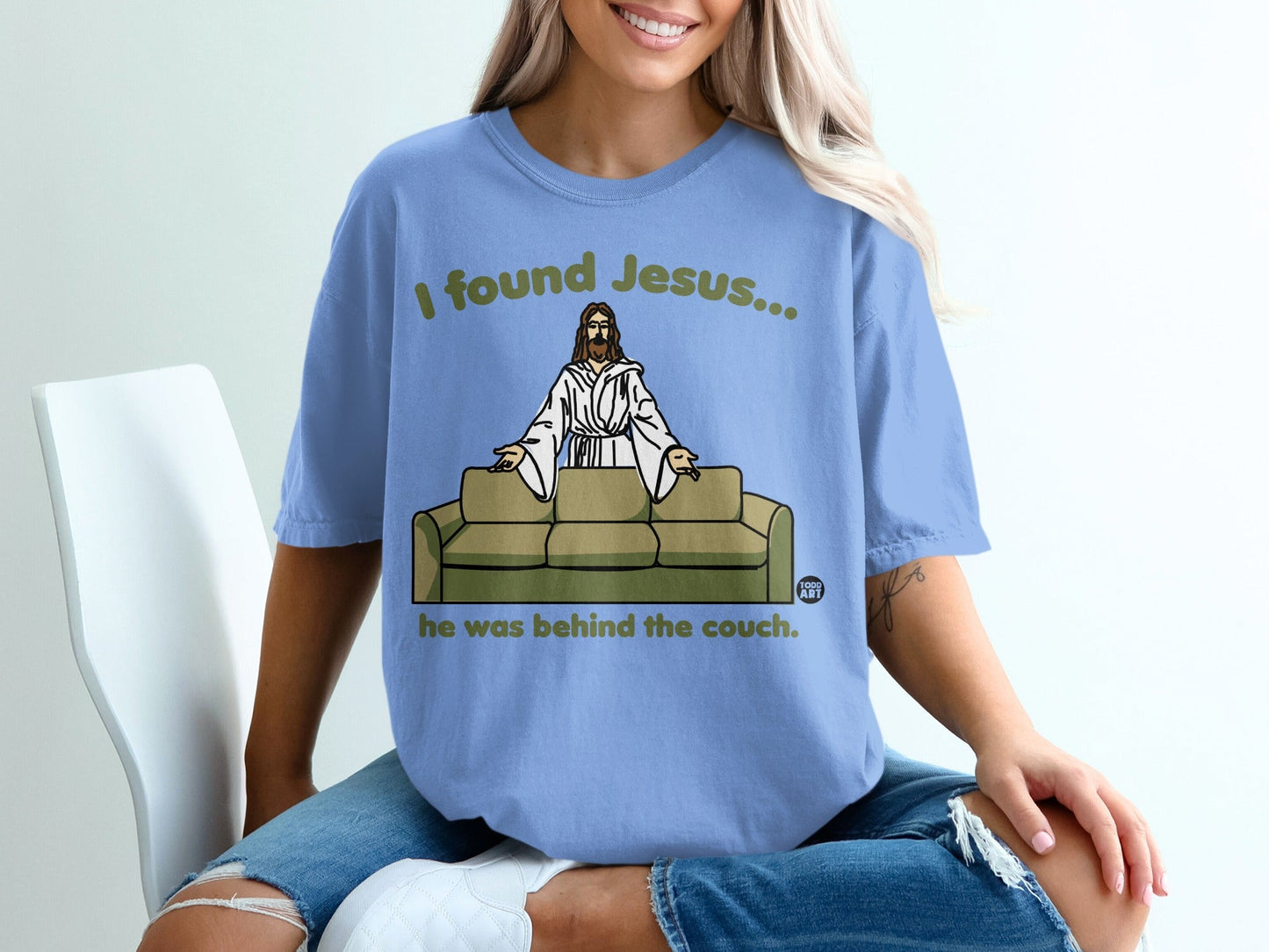 Light blue t-shirt with "I found Jesus... he was behind the couch" text.