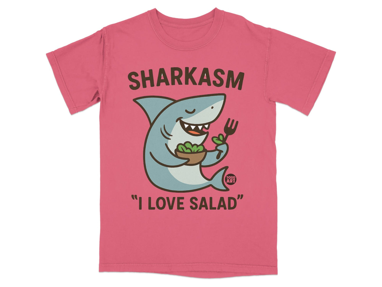 Pink t-shirt with cartoon shark holding salad and fork, text reads "SHARKASM I LOVE SALAD".