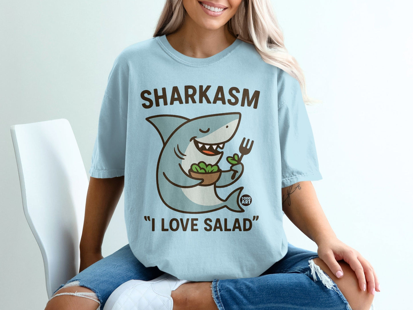 Light blue t-shirt with cartoon shark holding salad bowl, "SHARKASM" and "I LOVE SALAD".