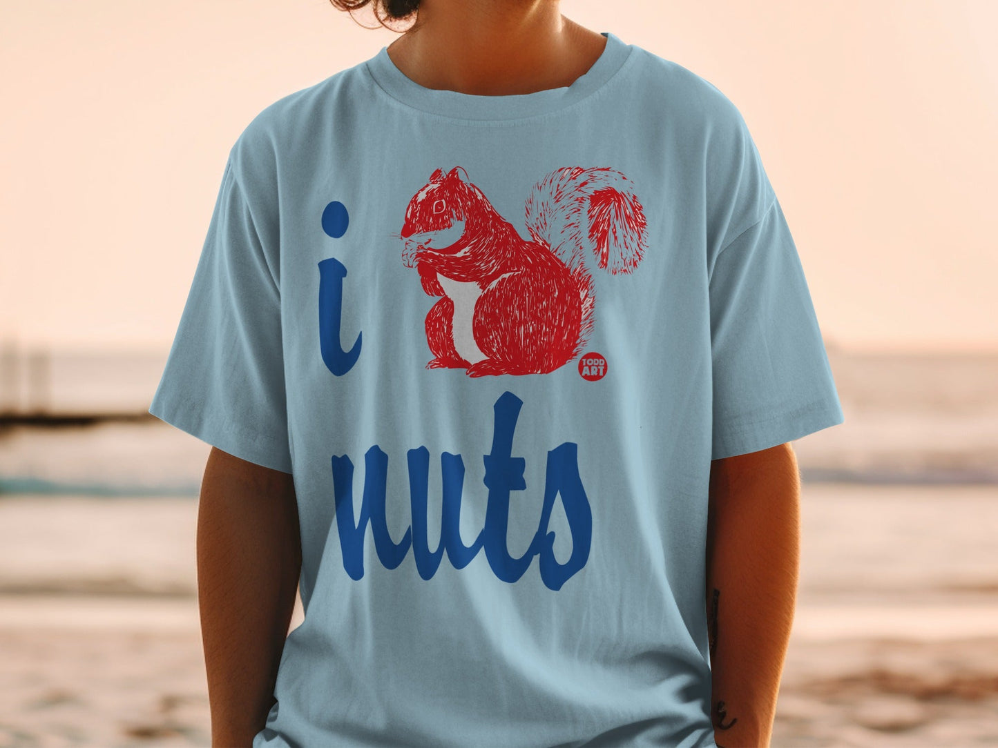 Light blue t-shirt with a red graphic of a squirrel and "i nuts" text.