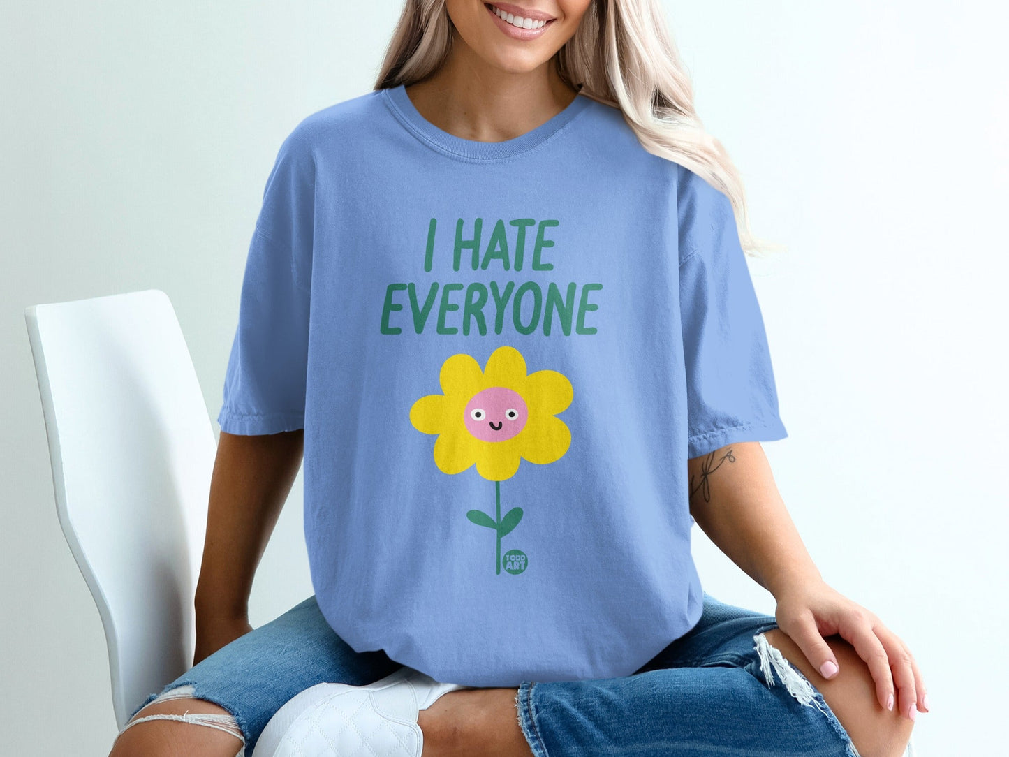 Blue t-shirt with "I HATE EVERYONE" text and a smiling yellow flower graphic.