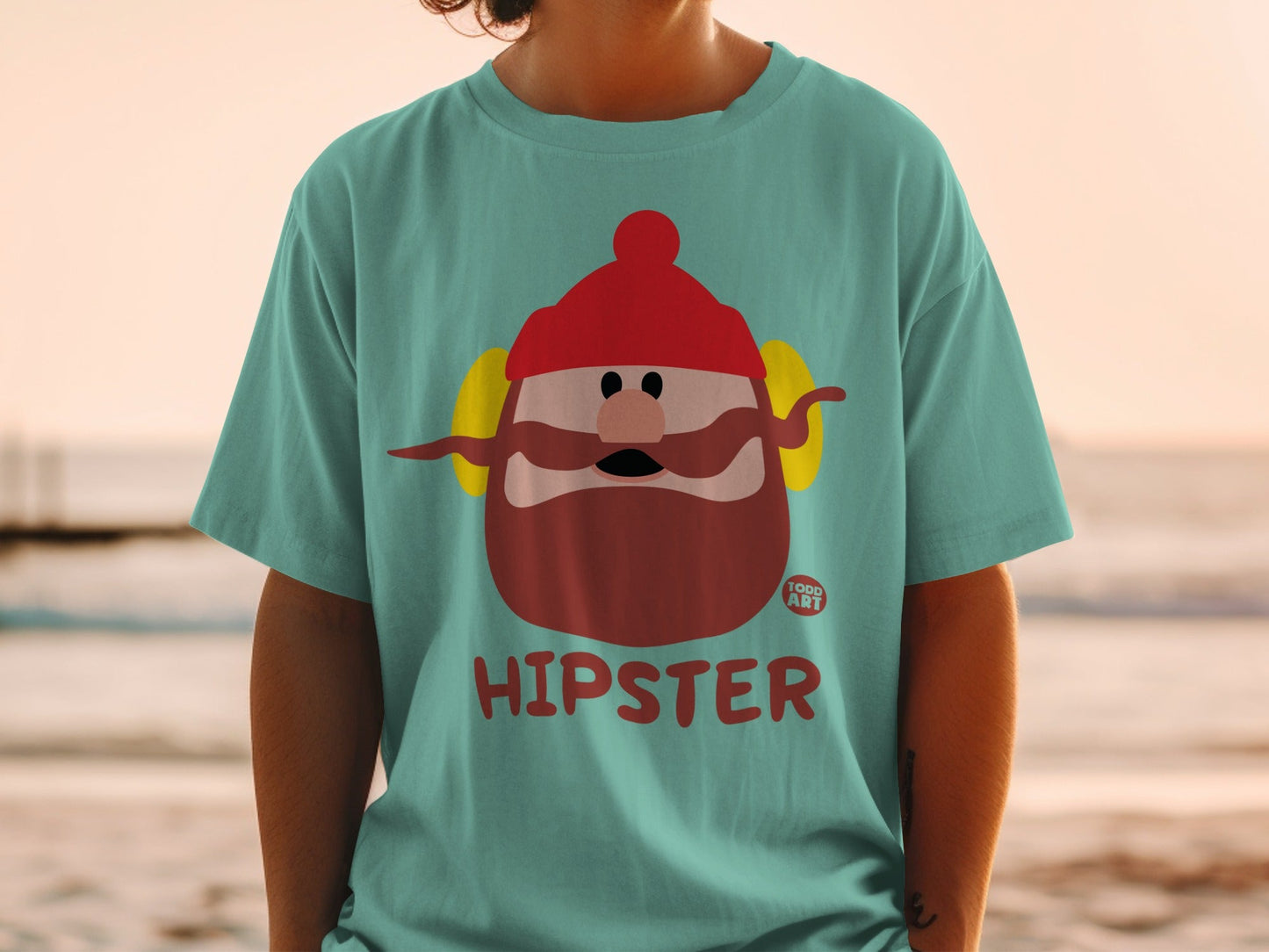 Teal t-shirt with a cartoon hipster character wearing a red hat and headphones.