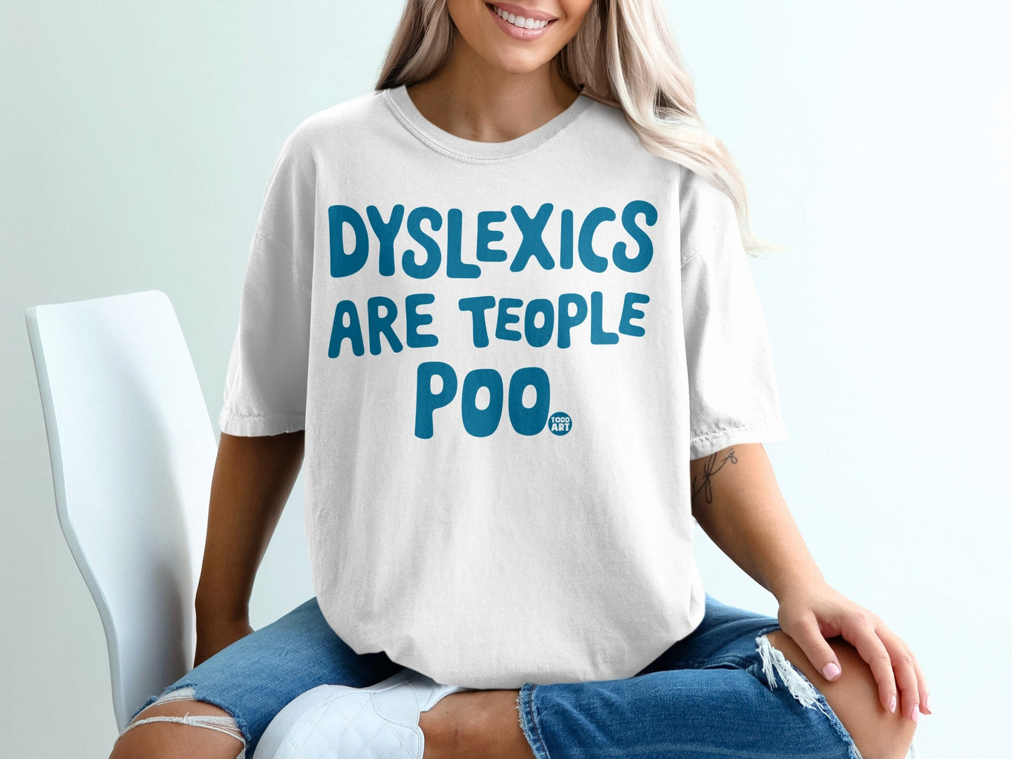White t-shirt with "DYSLEXICS ARE TEOPLO POO" and "FORGE ART" in blue text.