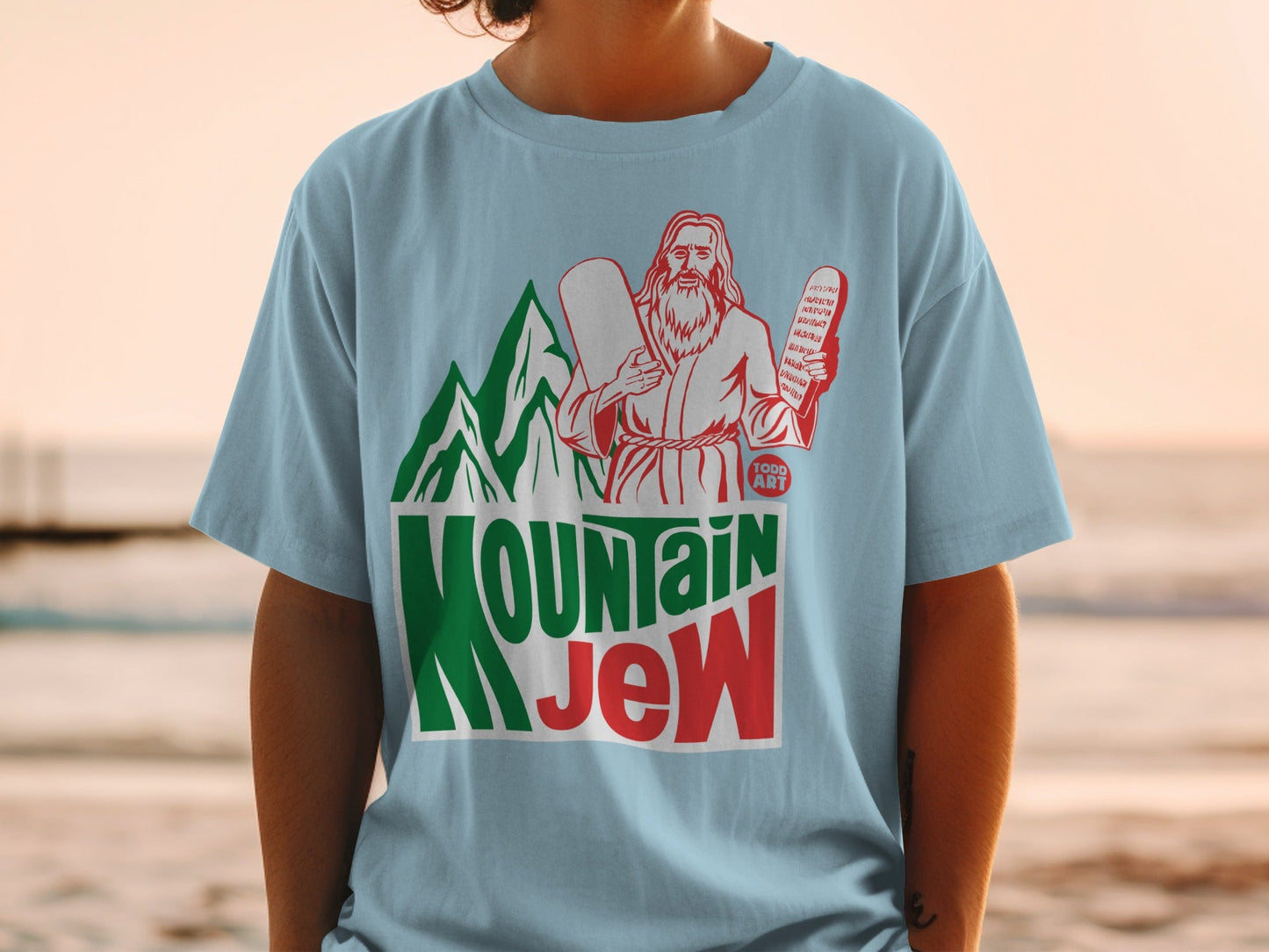 Light blue t-shirt with "Mountain Jew" text and biblical imagery.