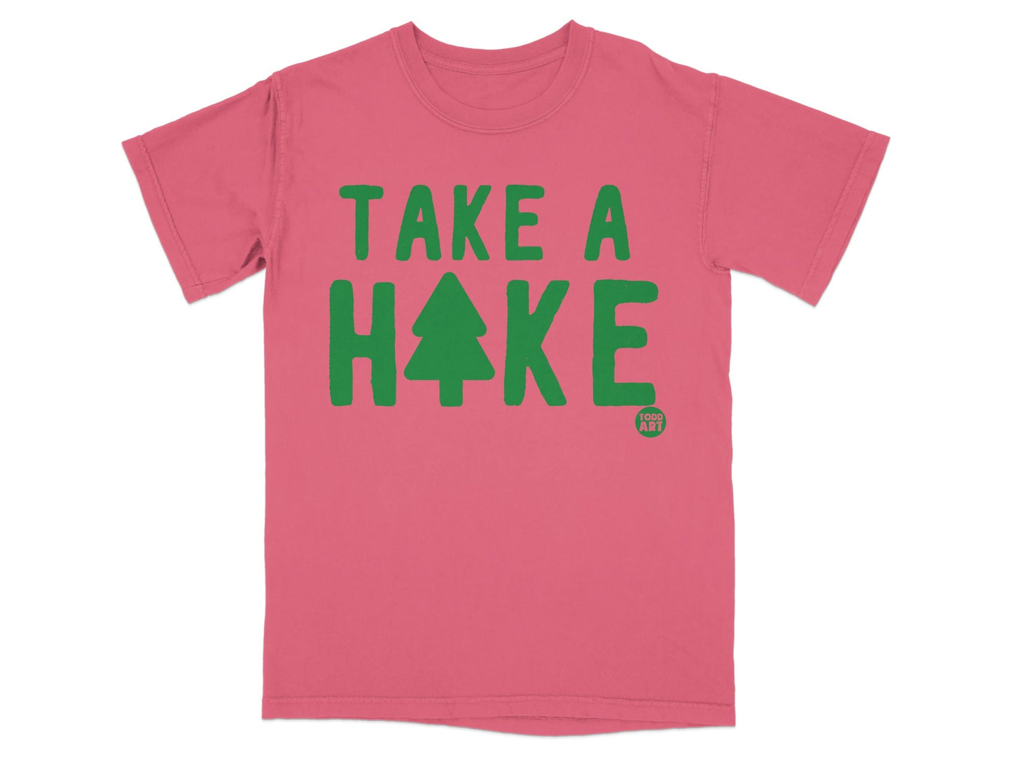 Pink t-shirt with green "TAKE A HIKE" text and a small Christmas tree graphic.