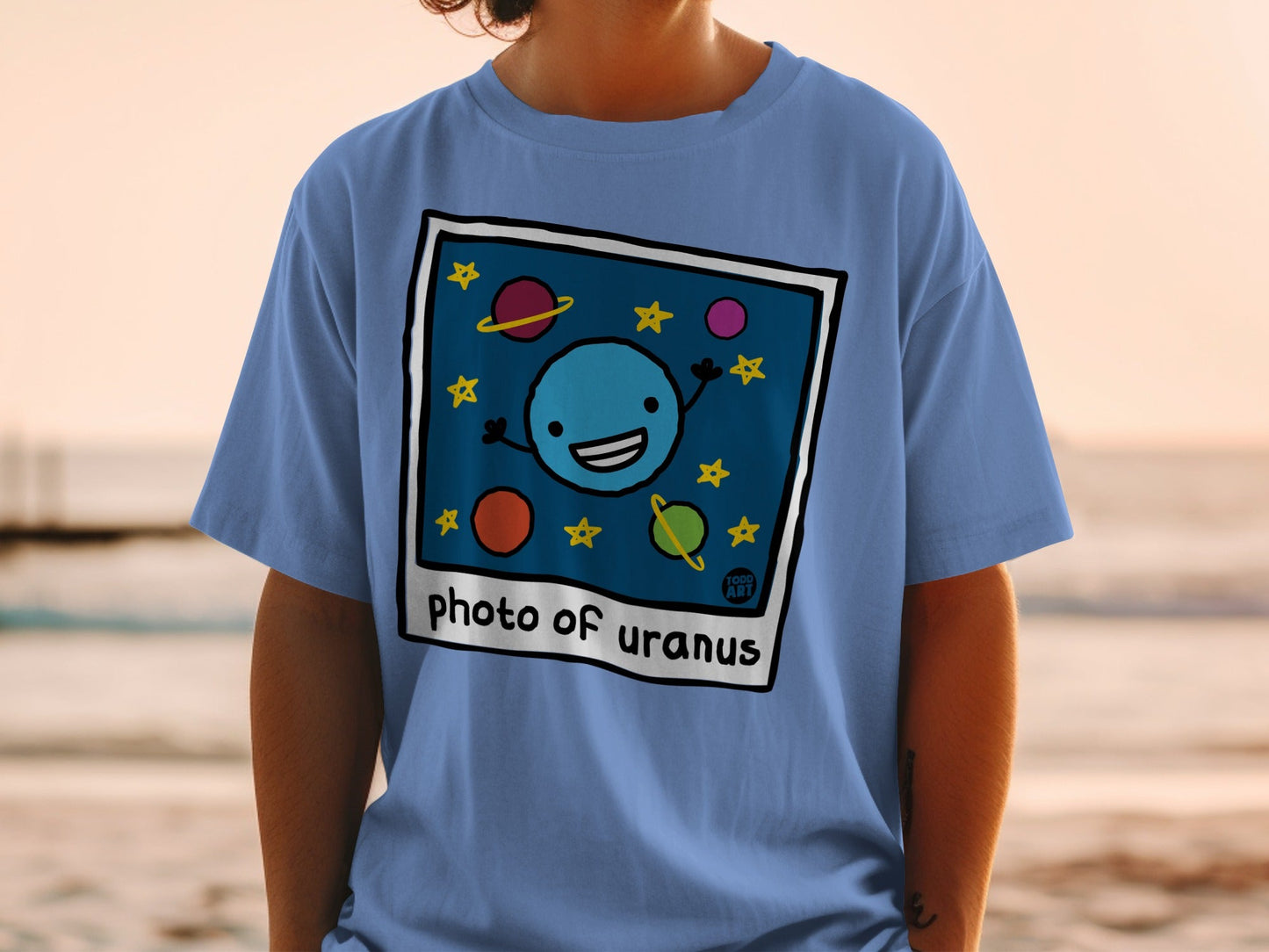 Blue t-shirt with cartoon Uranus smiling among stars and planets.