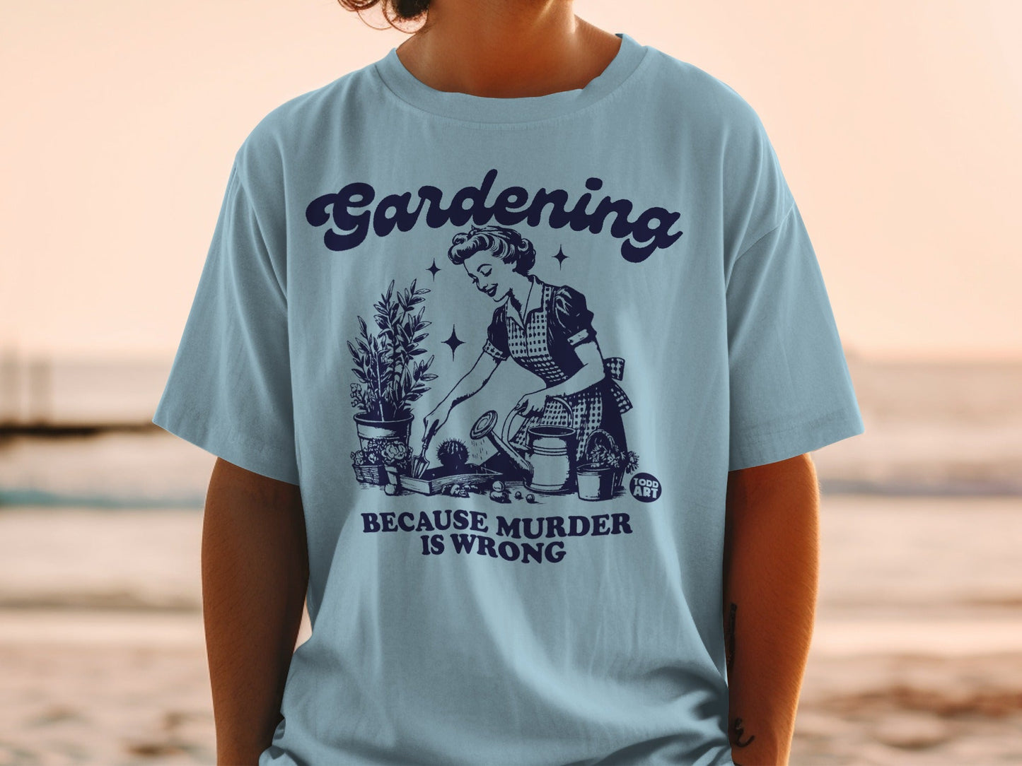 Light blue t-shirt with vintage gardening illustration and text "Gardening because murder is wrong".