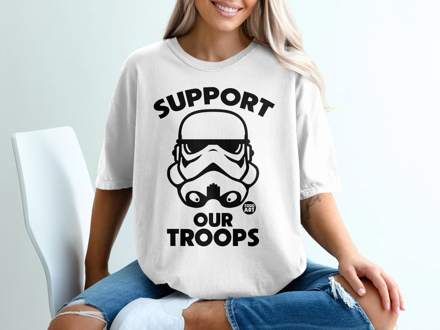 Black Stormtrooper helmet graphic with "SUPPORT OUR TROOPS" text on a white t-shirt.