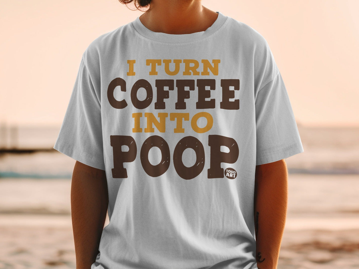 Grey t-shirt with brown and gold text reading "I TURN COFFEE INTO POOP".