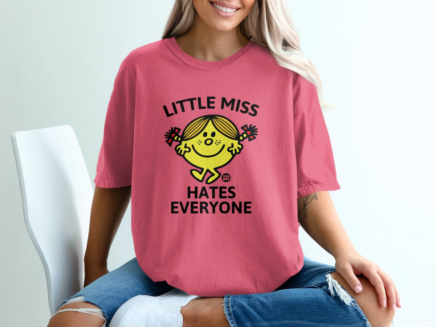 Pink t-shirt with "Little Miss Hates Everyone" text and smiley face graphic.