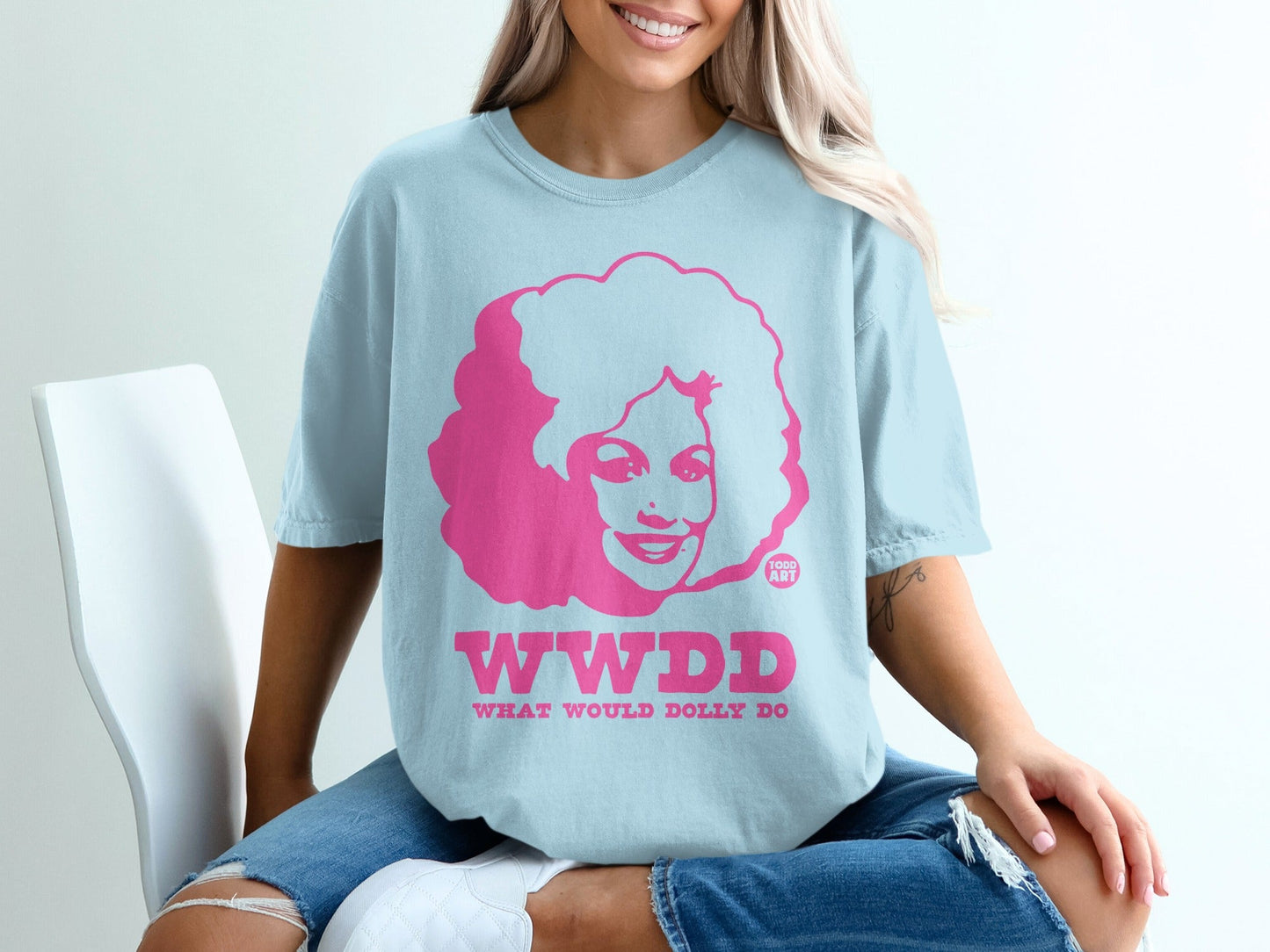 Light blue t-shirt with pink "WWDD What Would Dolly Do?" text and Dolly Parton graphic.