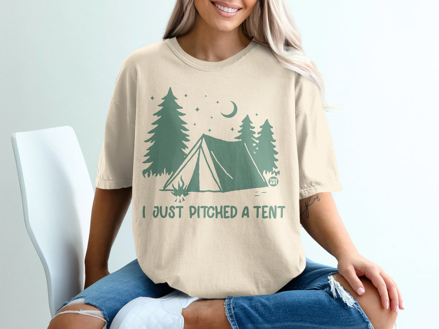 Light tan t-shirt with a green camping graphic and text "I JUST PITCHED A TENT".