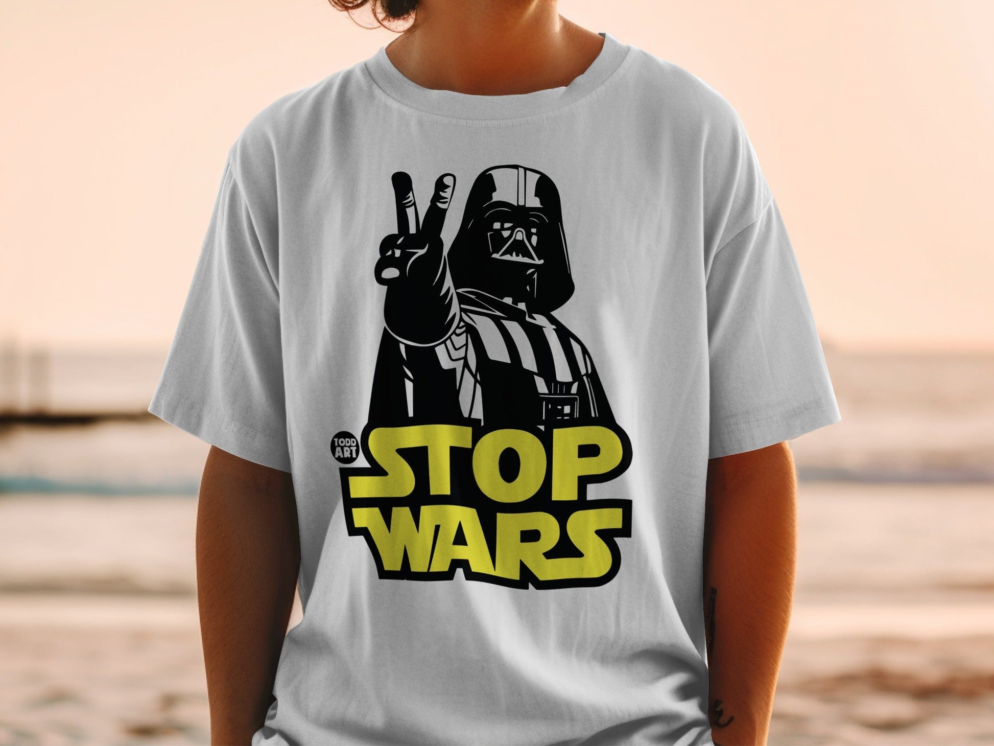 Darth Vader on white t-shirt giving peace sign, "STOP WARS" text.