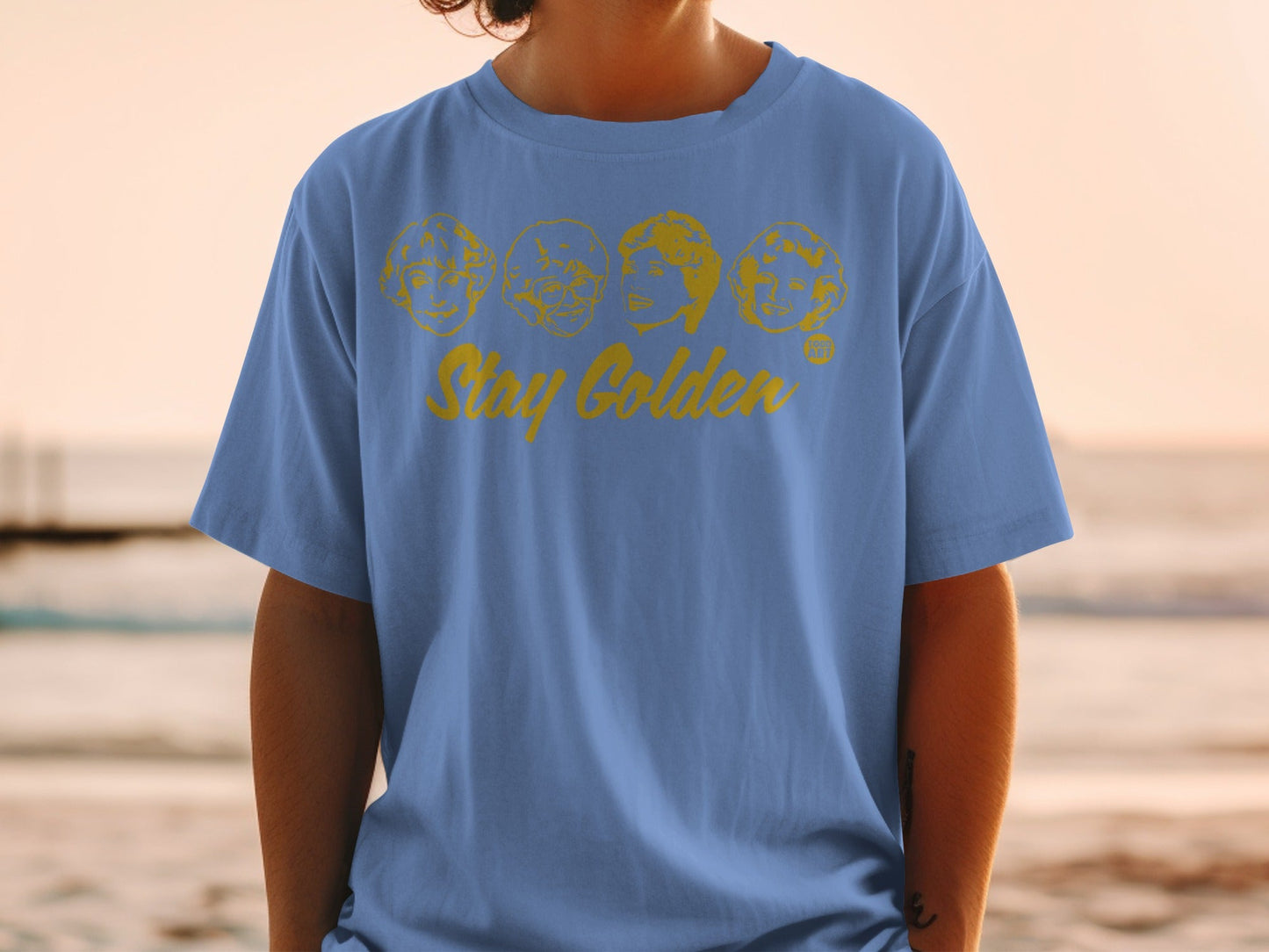 Blue t-shirt with "Stay Golden" and four cartoon faces.