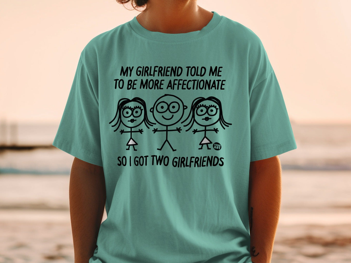 T-shirt with stick figures and text: "My girlfriend told me to be more affectionate so I got two girlfriends."