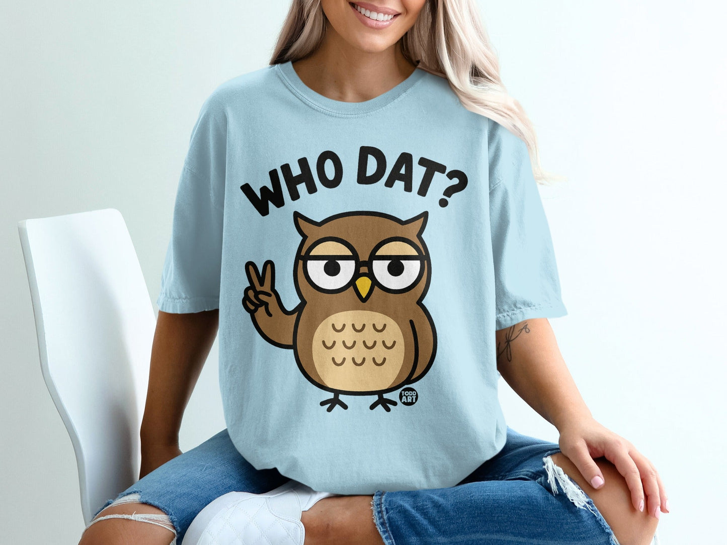 Light blue t-shirt with a cartoon owl making a peace sign and "WHO DAT?" text.