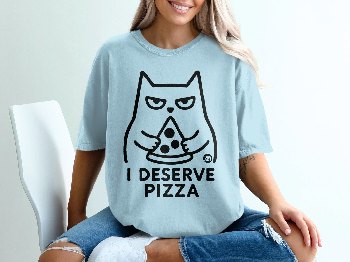 Light blue t-shirt with a cartoon cat holding a slice of pizza and text that reads "I DESERVE PIZZA".
