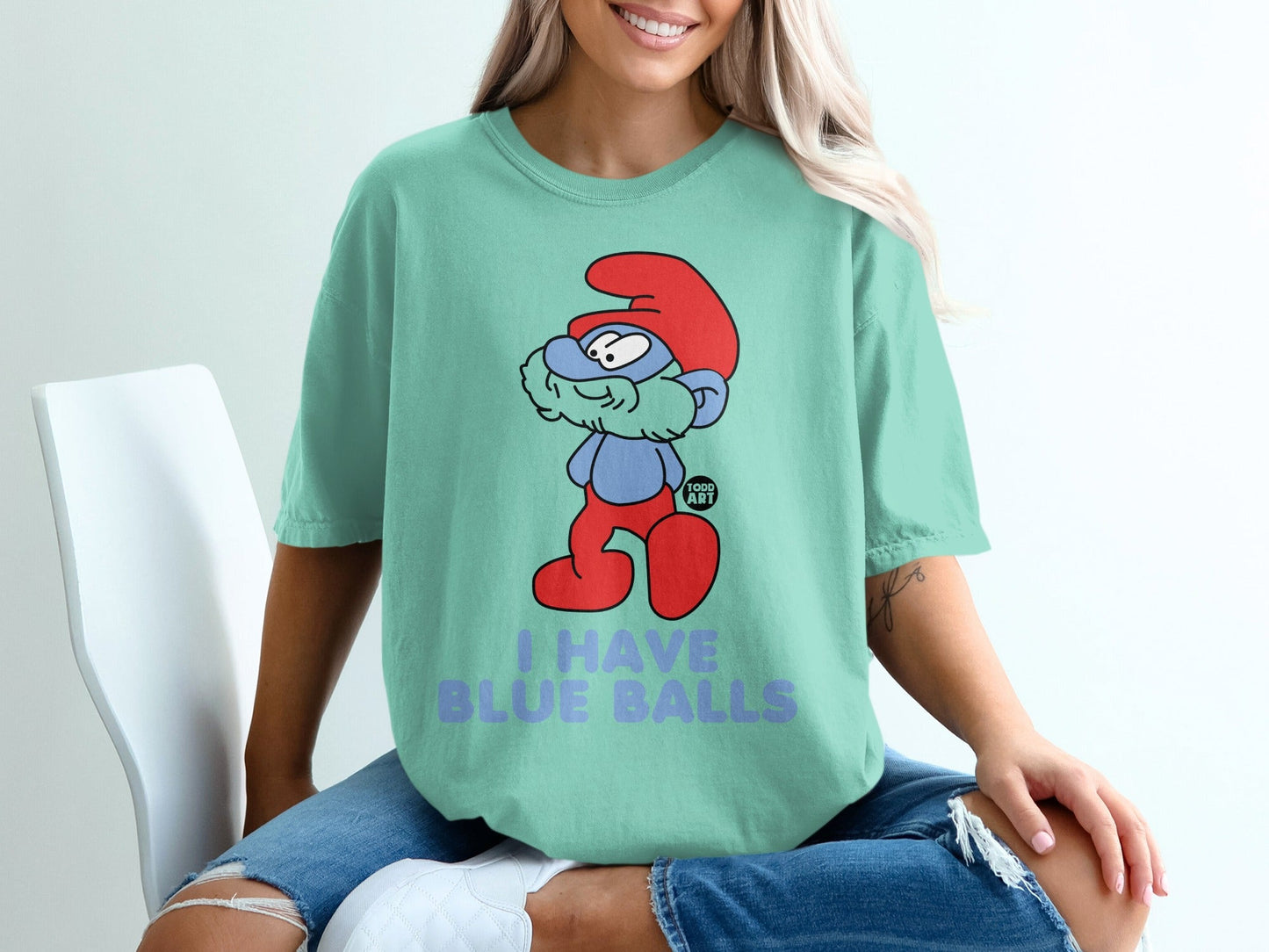 Smurf character with red hat and blue pants on teal t-shirt that says "I HAVE BLUE BALLS".