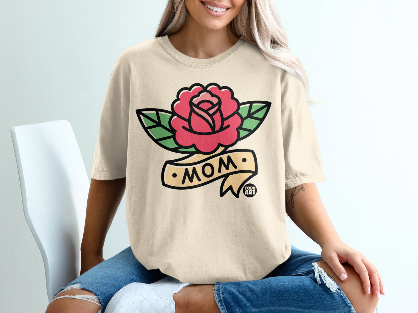 Cream t-shirt with red rose and "MOM" banner tattoo design.