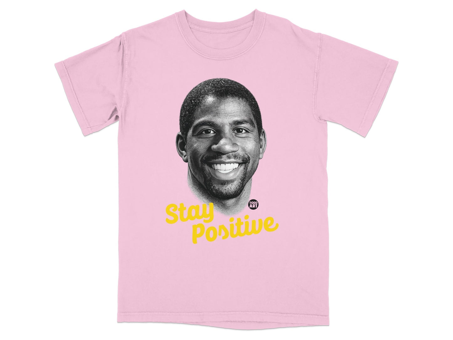 Pink t-shirt featuring a black and white portrait of Magic Johnson with "Stay Positive" text.