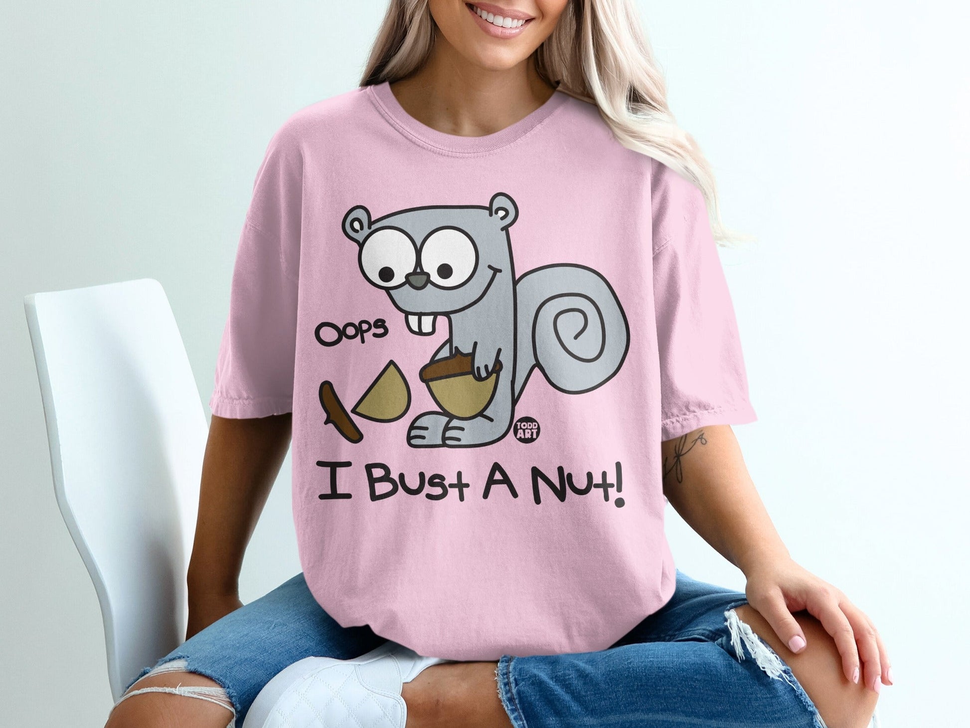 Pink t-shirt with cartoon squirrel saying "Oops I Bust A Nut!".